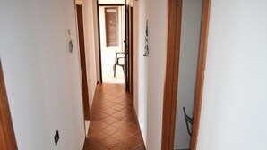 A hallway with tiled flooring, a chair, and a door. - Casa vacanze Ureshii a San Foca (San Foca)