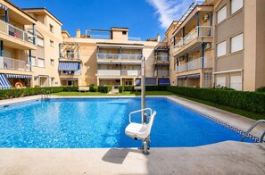 A swimming pool with a lifeguard chair, surrounded by multi-story buildings with balconies. - Lentiscares 213 Beach & Pool – Torrox Costa (Torrox Costa)