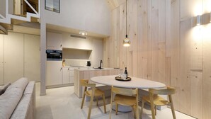 Un interior moderno con comedor, cocina y escalera.
