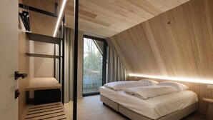 A modern bedroom with a bed, bedside table, and a built-in bench with storage.