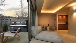Un interior moderno con sofá, una mesita y un jacuzzi exterior.