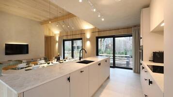 A modern kitchen with a large island, a built-in oven, and a large window.