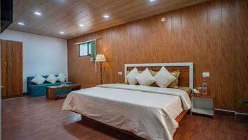 Un dormitorio con una cama grande, una mesita de noche, una lámpara, un armario y un sofá.