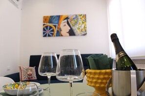 A dining table with two wine glasses, a bottle of champagne, and a decorative bowl. - Da Rosalia Apartment: all the comforts in the heart of Palermo's historic center (Palermo)