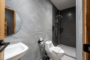 Ein Badezimmer mit Toilette, Waschbecken und Dusche.