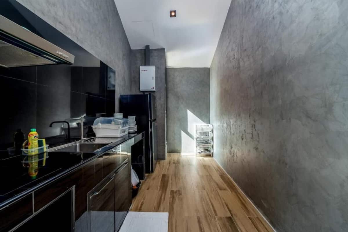 A modern kitchen with a black countertop, stainless steel appliances, and a visible water heater.