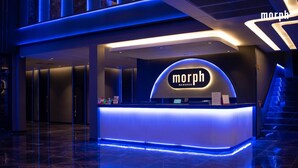 A modern reception desk with a neon sign reading 'Morph Bangkok' in a hotel lobby. - morph Bangkok Hotel (Bangkok)