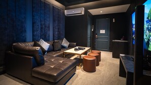 A modern lounge with a leather sofa, a marble coffee table, and a television screen. - morph Bangkok Hotel (Bangkok)