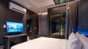 A modern hotel room with a large bed, a flat-screen TV, an air conditioning unit, and a window with curtains. - morph Bangkok Hotel (Bangkok)