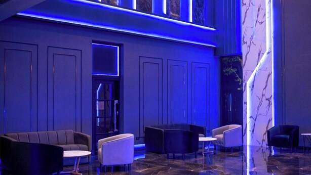 A modern lobby with a marble floor, blue ambient lighting, and contemporary furniture. - morph Bangkok Hotel (Bangkok)