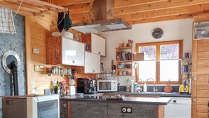 Una cucina moderna con mobili in legno, piano cottura integrato ed elettrodomestici, inclusa una lavastoviglie.