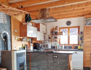 A modern kitchen with wooden cabinets, a built-in stove, and a dishwasher. - Chalet Retreat Private Self Contained 4 to 6 Person Mountain Views Own Terrace (Les Villards-sur-Thônes)