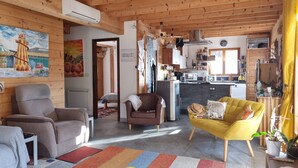 Un accogliente soggiorno con divano, poltrona e un tappeto colorato.