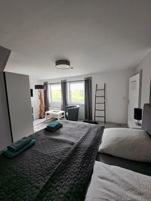 A hotel room with a bed, a desk, a chair, a ladder, and a window with curtains. - Vacation home/group house for up to 14 people Holl & Boll Pet-friendly (Clausthal-Zellerfeld)