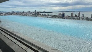 Blick auf das Wasser mit Schwimmbad, Stadtpanorama und bewölktem Himmel.