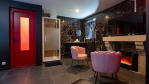 Ein modernes Interieur mit einer roten Tür, einem Kamin und zwei rosafarbenen Stühlen.