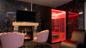 Ein modernes Interieur mit Fernseher, Kamin und einer Sitzgruppe in rotem Licht.