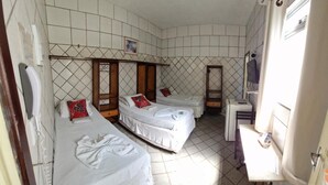 A room with two single beds, a small table, a mirror, and a window. - Hotel Pilão (São Luis)