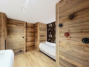 Ein modernes Schlafzimmer mit Holzwänden, einem Bett und einem einzigartigen Wandbild.