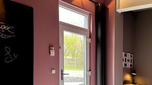 A modern room with a blackboard, a desk, and a window with curtains.