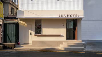 A hotel named LUA HOTEL with a simple facade, a small entrance, and a visible Christmas tree.