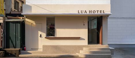 Hotel LUA HOTEL met een eenvoudige gevel, een kleine ingang en een zichtbare kerstboom.