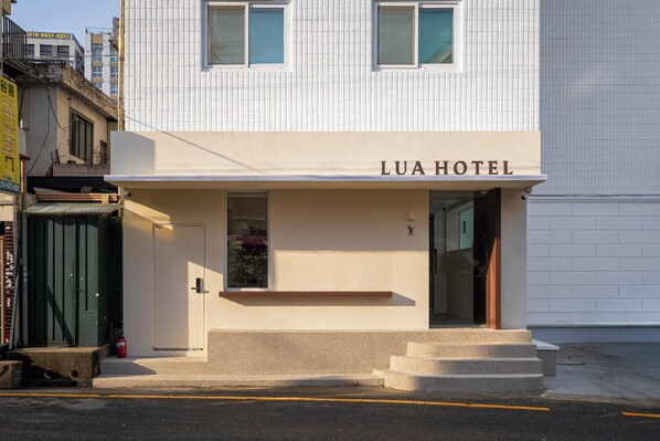 A hotel named LUA HOTEL with a simple facade, a small entrance, and a visible Christmas tree. - Lua Hotel (Seoul)