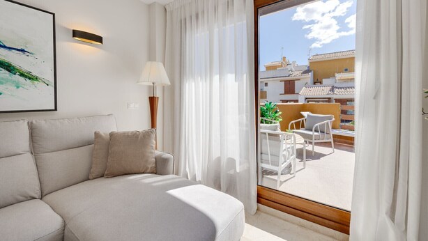 Une chambre d’hôtel avec un lit, une lampe, un tableau et une vue sur l’extérieur.