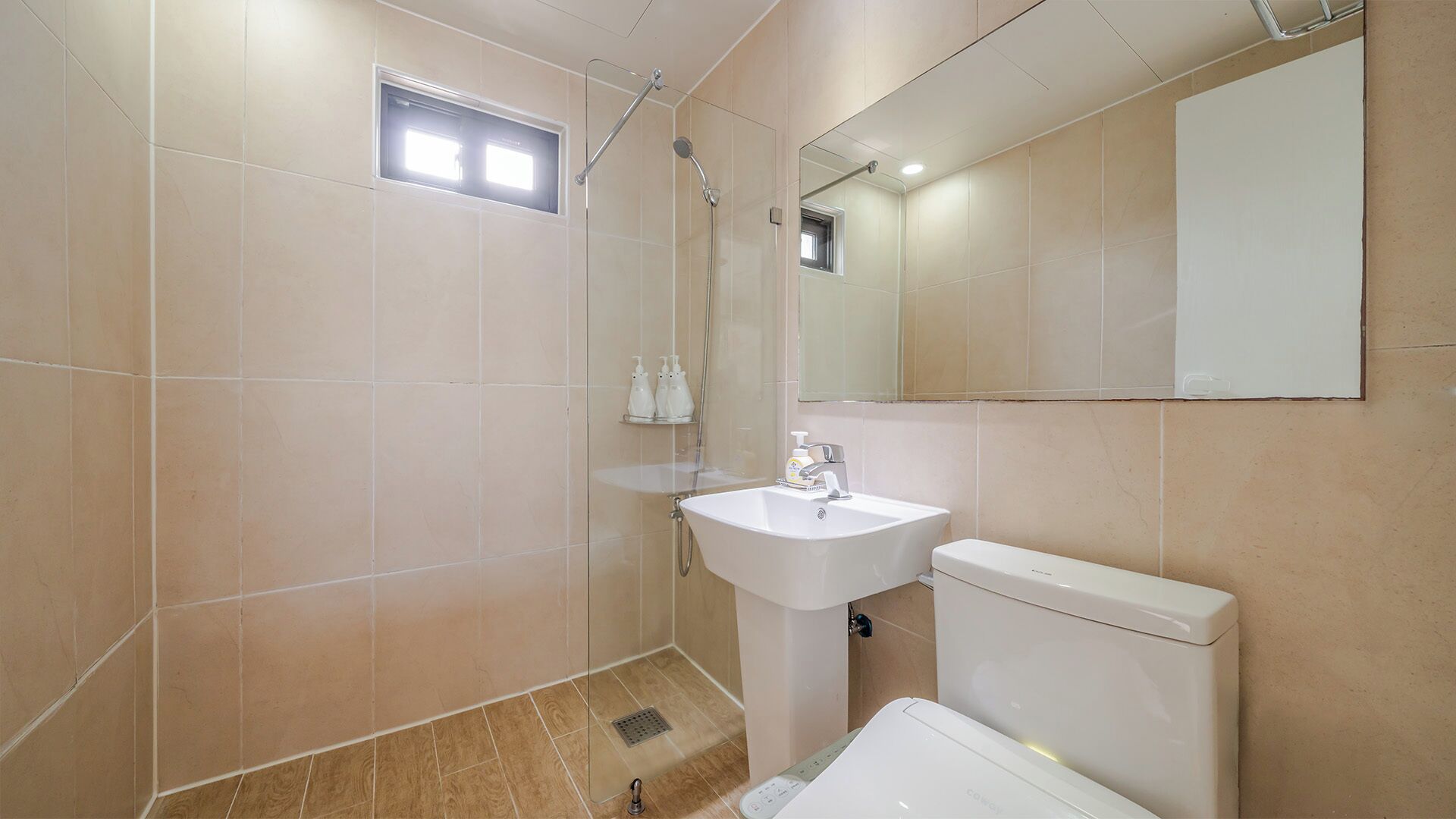 Un baño con ducha, lavabo, inodoro y espejo.