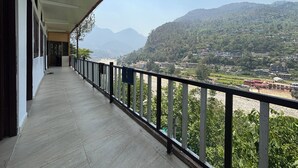 Un balcón con vistas a un paisaje montañoso y un río.