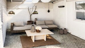 A cozy patio area with a sofa, a coffee table, and decorative items. - Beautiful home in Saltum with WiFi (Saltum)