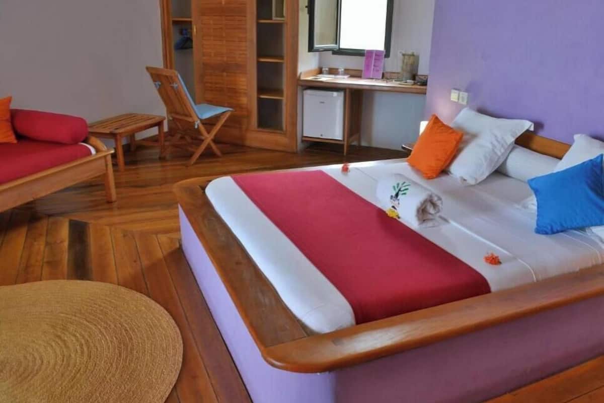 A bedroom with a bed, a desk, a chair, and a wardrobe.