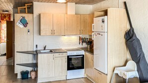A compact kitchen with wooden cabinets, a sink, a stove, and a refrigerator. - Amazing home in Vestervig with sauna (Vestervig)
