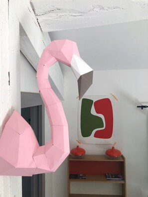 A room with a pink paper sculpture, a wooden shelf with books, and a wall with a geometric painting. - Mazet in Isle sur la Sorgue (saumane)