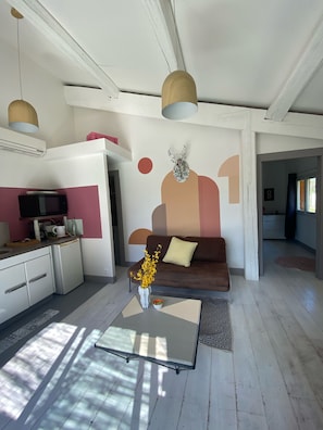 A modern living room with a sofa, coffee table, and decorative vase. - Mazet in Isle sur la Sorgue (saumane)