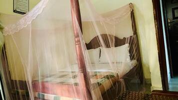 A bed with a wooden frame and a mosquito net.