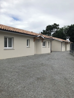 A building with a tiled roof, multiple windows, and a gravel driveway. - House in Le Teich; nature and beaches nearby (Le Teich)