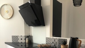 Una cocina moderna con armarios blancos, encimera negra y salpicadero geométrico.