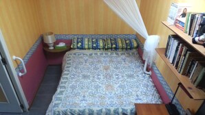 A bedroom with a bed, bedside table, lamp, and a bookshelf. - Ground floor cottage Gite with disabled access-Swimming pool-Jacuzzi (Le Poujol-sur-Orb)