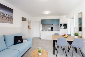 A modern apartment with a living area, kitchenette, and dining space. - MEERholung Vacation Rental 3.3 – 400 m from the sea, with a balcony, for up to 4 guests - House (Cuxhaven)