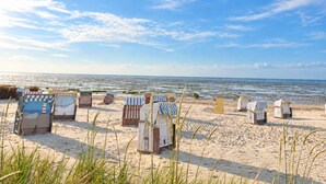 En strand med flera strandhytter och en fri utsikt över havet.