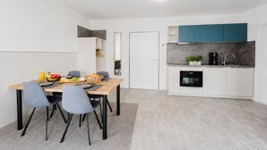 A compact kitchen with a built-in oven, a coffee maker, and a sink. - MEERholung Vacation Rental 2.8 with Balcony, Just 400 m from the Sea - MEERholung House (Cuxhaven)