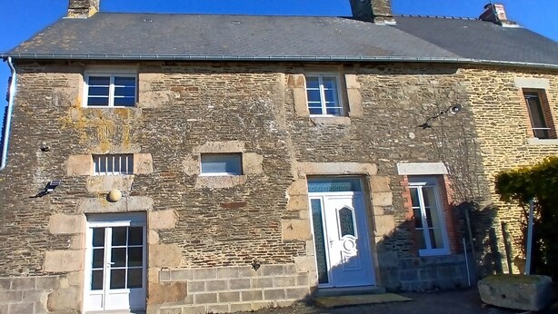 Un bâtiment en pierre doté de nombreuses fenêtres et portes, présentant un style architectural traditionnel.