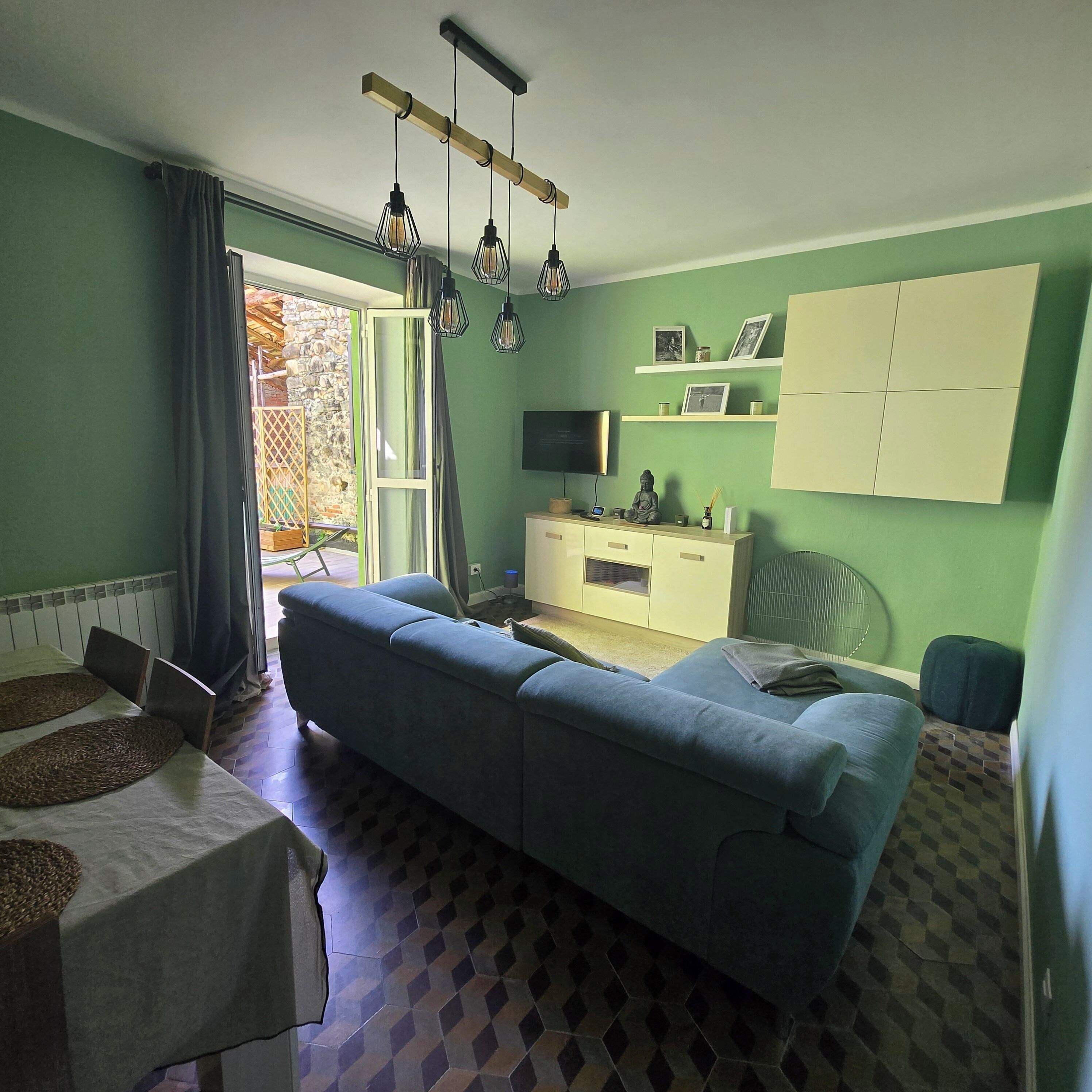 A room with a sofa, a TV, a cabinet, and a window.