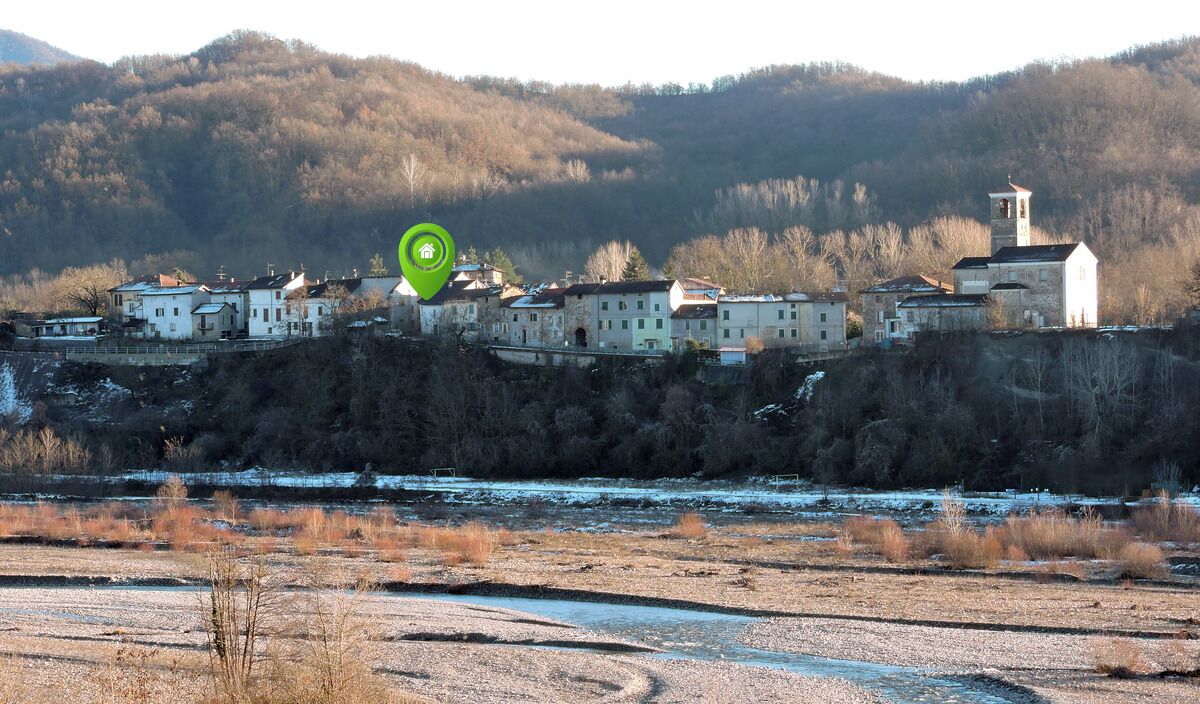 A riverside village with buildings, a church, and a tower.