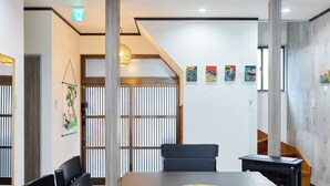 Une salle de conférence avec une longue table, des chaises, un set de table en fibres tressées et des œuvres d’art accrochées au mur.