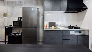 Une cuisine moderne équipée d’un réfrigérateur en acier inoxydable, d’un four à micro-ondes et d’une hotte noire.