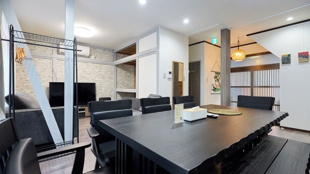 Une salle de conférence moderne, dotée d’une longue table, de chaises noires et d’un mur décoratif en pierre.