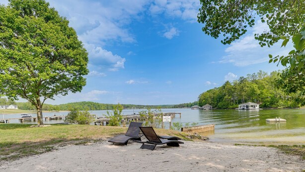 Une vue sur le lac, avec des chaises longues, un quai et un petit bâtiment situé au bord de l’eau.