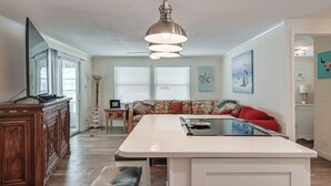 A modern kitchen with a central island, wooden cabinetry, and a ceiling fan. - Bonita Beach 7 Mi: 55+ Community w/ Pool Access (Bonita Springs)